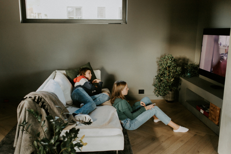 To ungdommer ser på TV i stuen