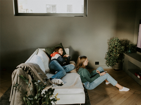 To ungdommer ser på TV i stuen